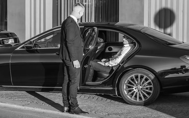 Chauffeur opening the door for client at airport 