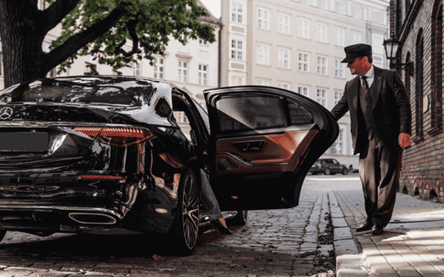 Chauffeur opening the door for the client. City transfer in Switzerland